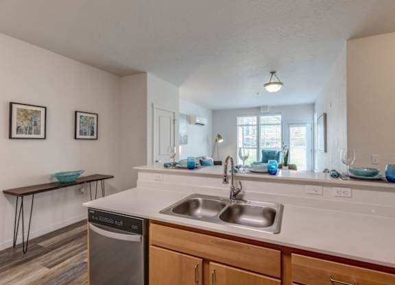 A kitchen with a white countertop and wooden cabinets.
