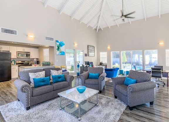 A living room with grey couches and a glass coffee table.