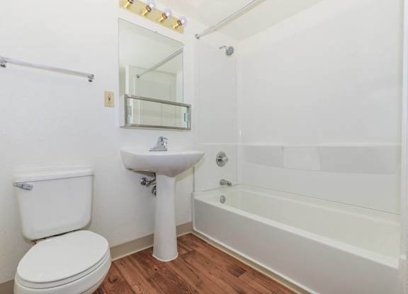 A white toilet sits next to a sink in a small bathroom.