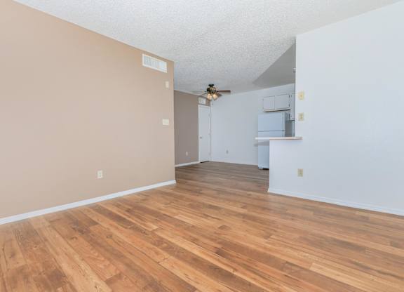 A room with wooden flooring and white walls.