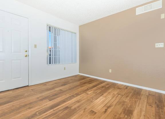 A room with a white door and a window with blinds.