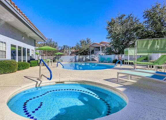 A swimming pool with a slide and a building in the background.