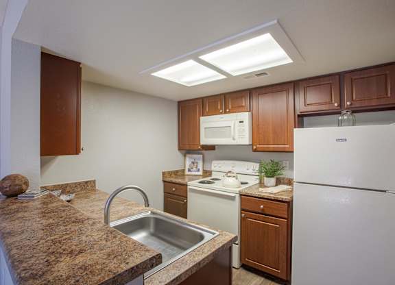 A kitchen with brown cabinets and a white refrigerator.