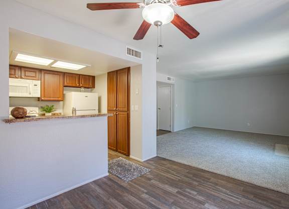 A room with a ceiling fan and wooden flooring.