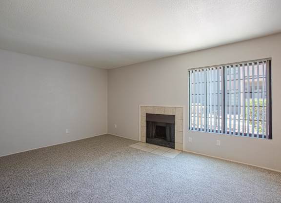 A room with a fireplace and a window with blinds.