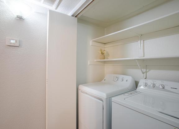 A white washing machine and dryer in a small laundry room.