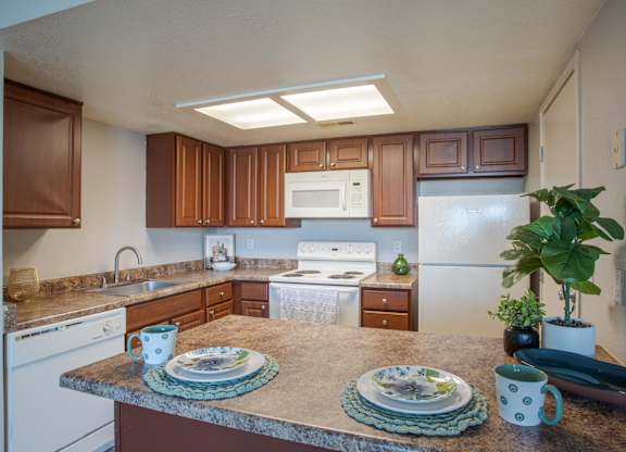 A kitchen with brown cabinets and white appliances.