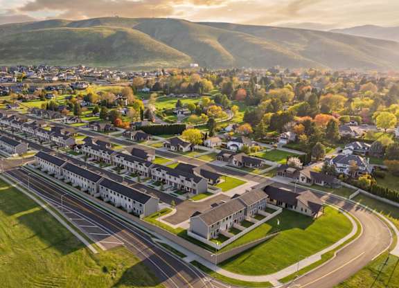 A suburban area with a road running through it and houses on both sides.
