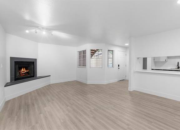 Spacious living room with a fireplace and wooden-style  flooring at The Rosewood Apartments in Vancouver, Washington.