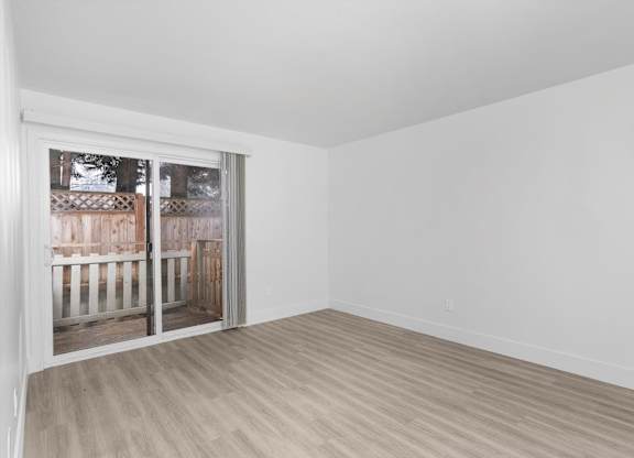 A room with a sliding glass door leading to a backyard.