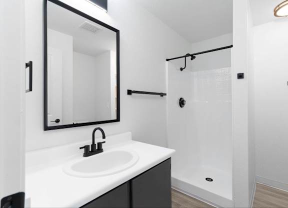 A modern bathroom with white walls and countertops with matte black finishes at The Rosewood Apartments in Vancouver, Washington.
