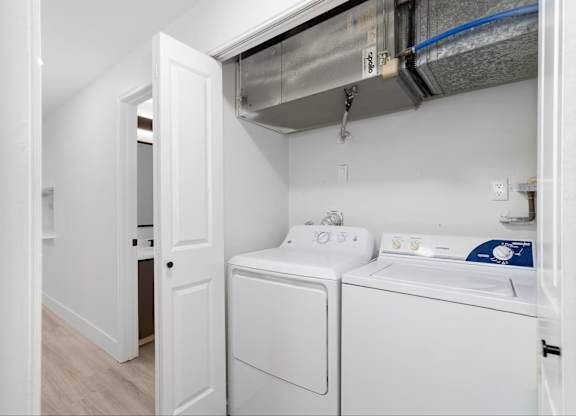 In-unit laundry with a washer and dryer machine at The Rosewood Apartments in Vancouver, Washington.