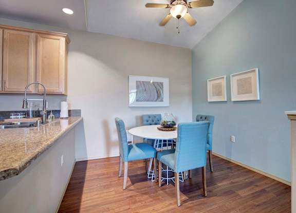 A kitchen with a table and chairs in the middle of the room.