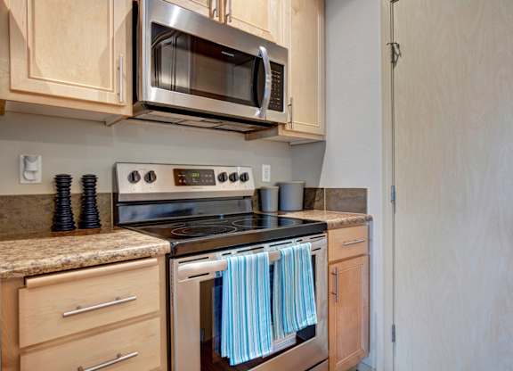 A kitchen with wooden cabinets and a stove top oven.