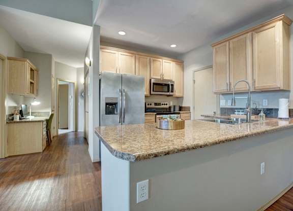 A kitchen with a granite countertop and stainless steel appliances.