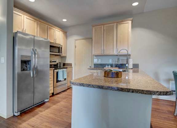 A kitchen with a granite countertop and stainless steel appliances.