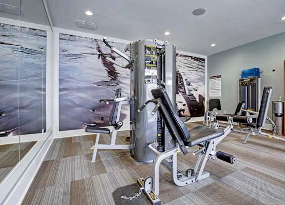 A gym with a variety of equipment including a leg press machine.