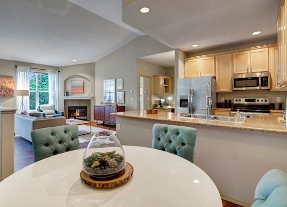A modern kitchen with a dining table in the middle.