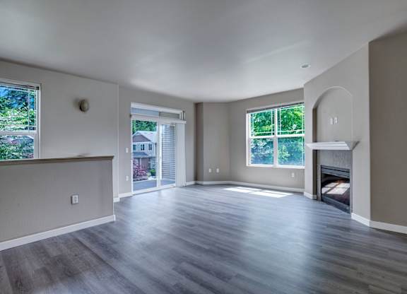 A spacious living room with hardwood floors and a fireplace.
