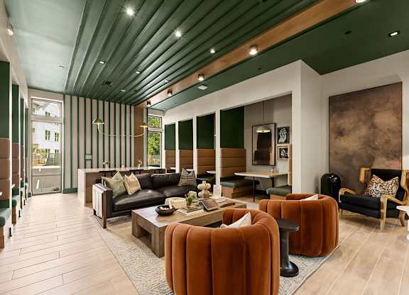 A modern living room with a black couch and a wooden coffee table.