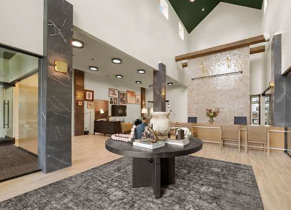 A modern living room with a black coffee table in the center.