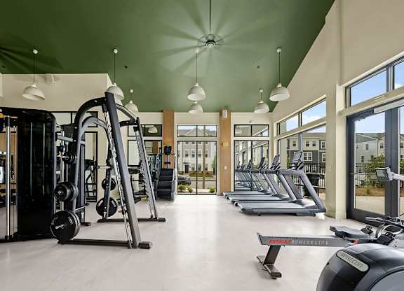 A gym with treadmills, weights, and exercise equipment.