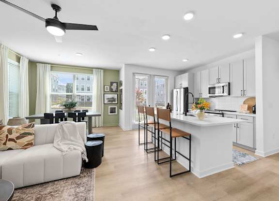 A modern kitchen with a white island and bar stools.