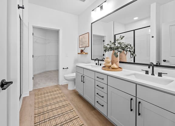 A bathroom with a white door and a brown rug.