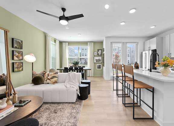 A modern kitchen with a white countertop and bar stools.