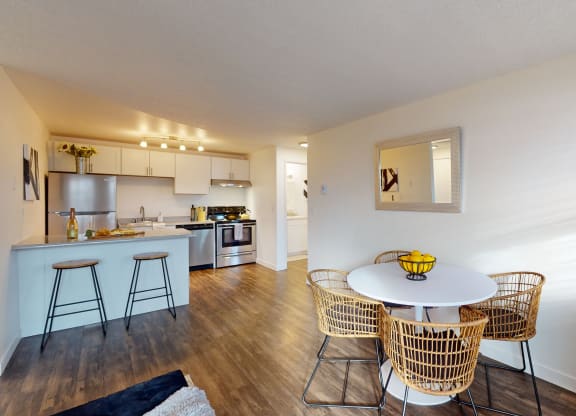 a living room with a table and chairs and a kitchen