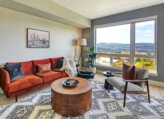 a living room with a red couch and a large window