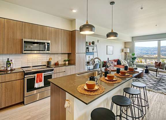a kitchen with a large island with a breakfast bar and a living room with a couch and