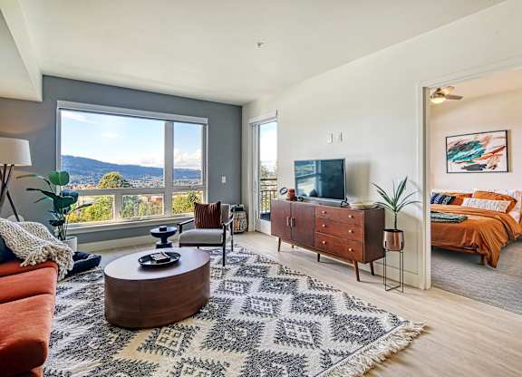 a living room with a tv and a bedroom in the background