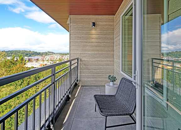 a balcony with a chair and a potted plant