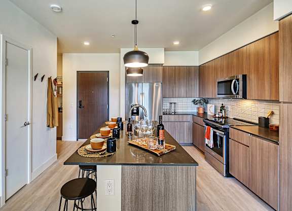 a kitchen with wooden cabinetry and a large island with a breakfast bar