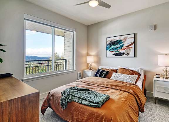a bedroom with a large window and a large bed
