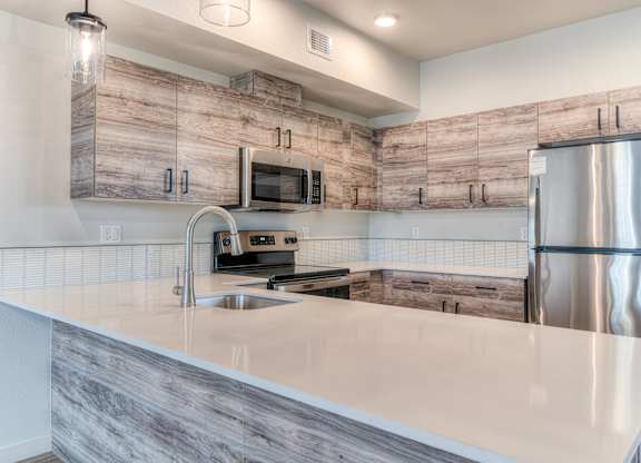 A modern kitchen with a wooden backsplash and stainless steel appliances.