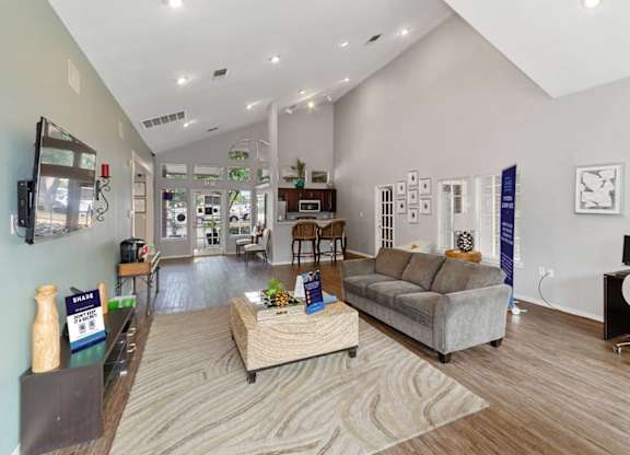 A living room with a couch, a coffee table, and a television.