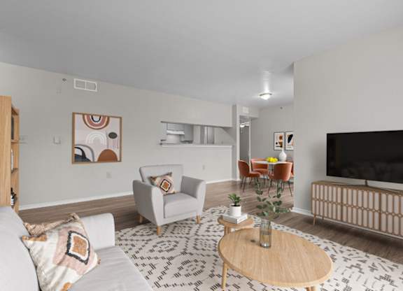 A living room with a grey couch, a wooden coffee table, and a television.