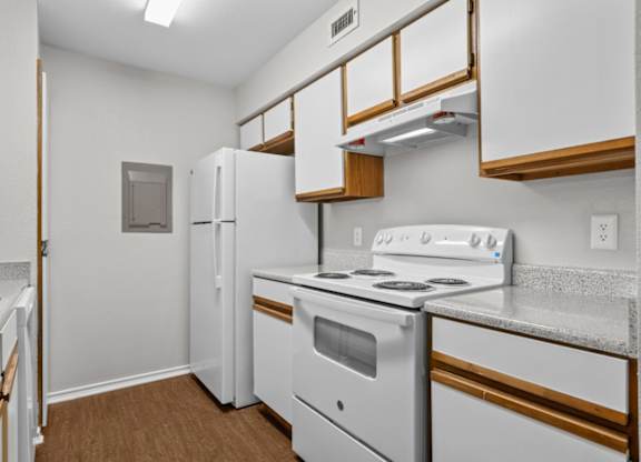 A kitchen with white appliances and wooden cabinets.
