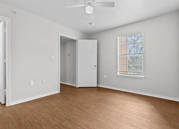 A room with a ceiling fan and a window.