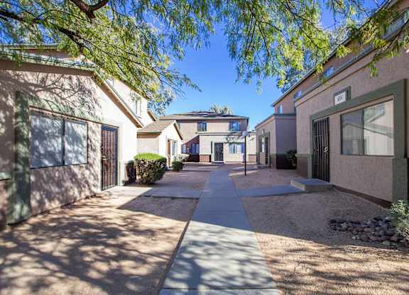 A sunny day in a residential area with houses and a sidewalk.