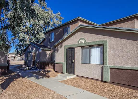 A house with a brown and beige exterior and a green door.