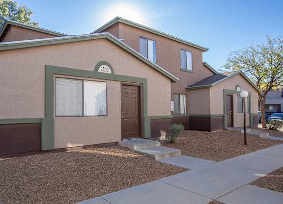A house with brown and green exterior and a brown door.
