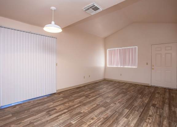 A room with wooden flooring and a white door.
