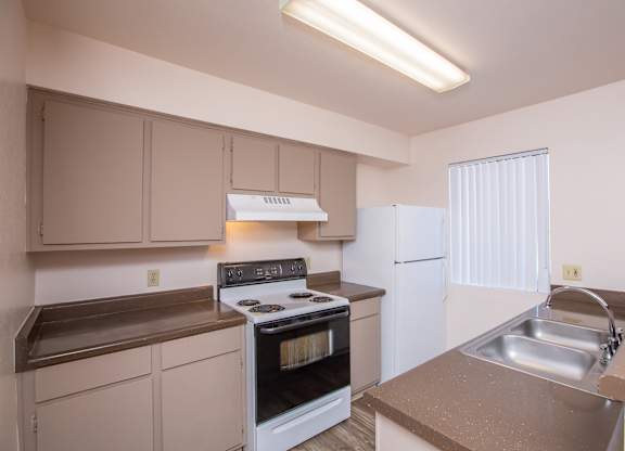 A kitchen with a stove, oven, and sink.