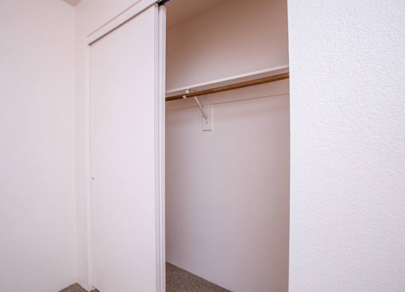 A white door is open to a white room.