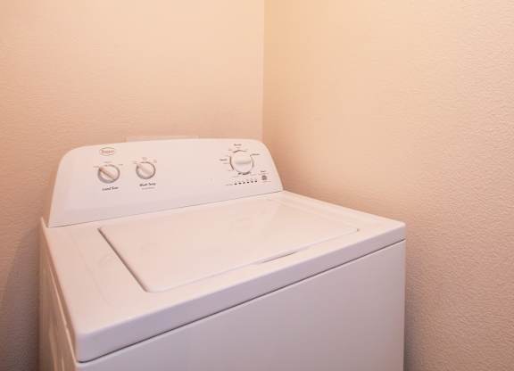A white washing machine with a control panel on top.