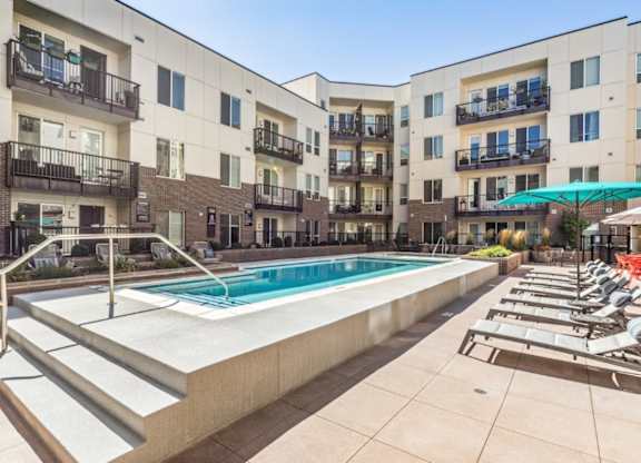 A swimming pool in front of apartment buildings.