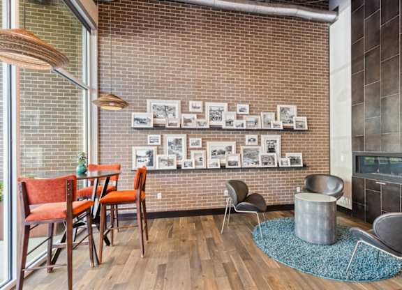 A living room with a brick wall and a fireplace.